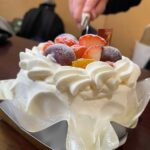 キャンプ場でデコレーションケーキに包丁を入れる様子