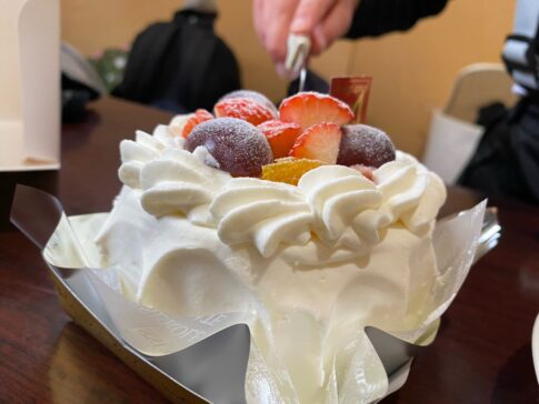 キャンプ場でデコレーションケーキに包丁を入れる様子