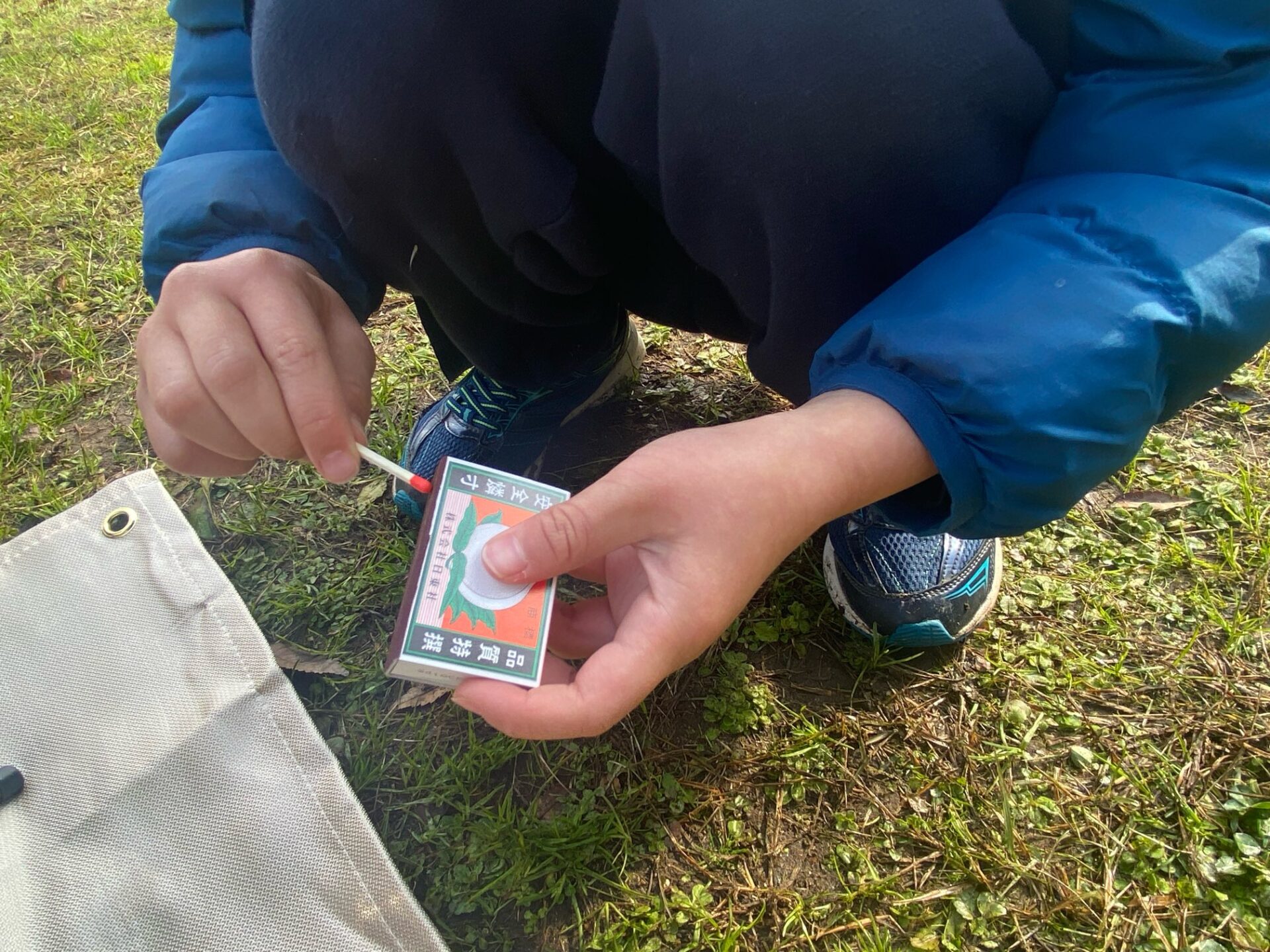 マッチで火おこしをする息子の様子