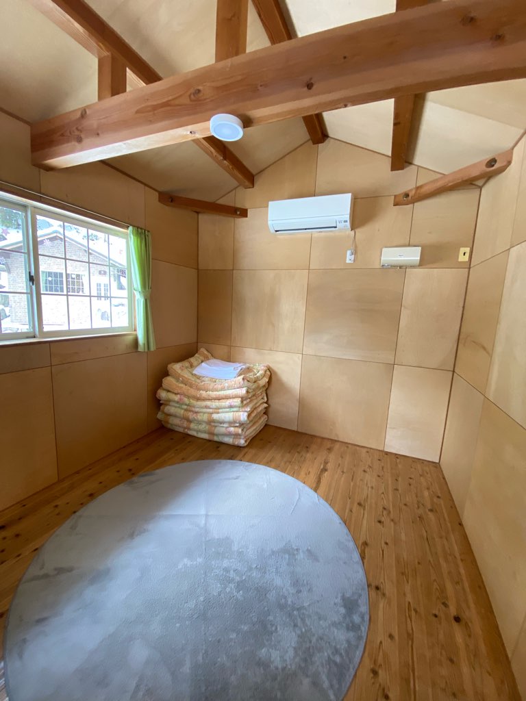 バンガローの室内写真 エアコンと布団のある風景